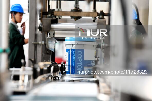 A worker produces lubricating oil on a production line at Qingdao Compton Technology Co LTD in Hongshiya Street, Qingdao, China, on October...