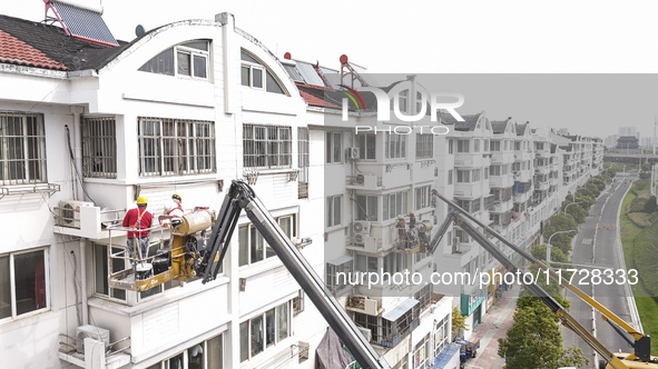 Workers renovate the Dongfeng Garden residential area in the Qingjiangpu district of Huai'an City, Jiangsu province, China, on November 1, 2...