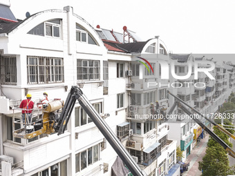 Workers renovate the Dongfeng Garden residential area in the Qingjiangpu district of Huai'an City, Jiangsu province, China, on November 1, 2...