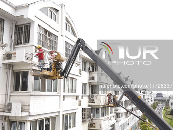 Workers renovate the Dongfeng Garden residential area in the Qingjiangpu district of Huai'an City, Jiangsu province, China, on November 1, 2...