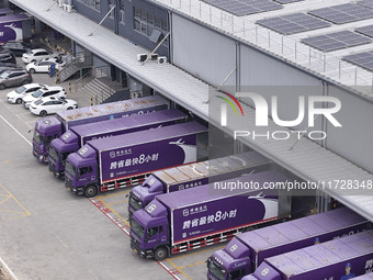 Express trucks from several companies load and unload parcels at a logistics park in the Huaian Economic and Technological Development Zone...