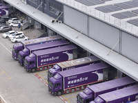 Express trucks from several companies load and unload parcels at a logistics park in the Huaian Economic and Technological Development Zone...