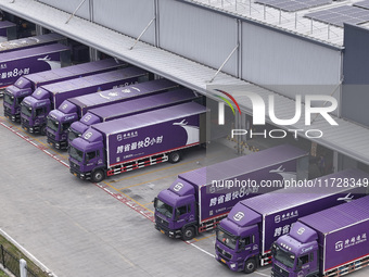 Express trucks from several companies load and unload parcels at a logistics park in the Huaian Economic and Technological Development Zone...