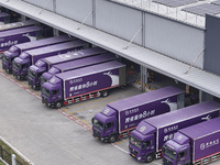 Express trucks from several companies load and unload parcels at a logistics park in the Huaian Economic and Technological Development Zone...