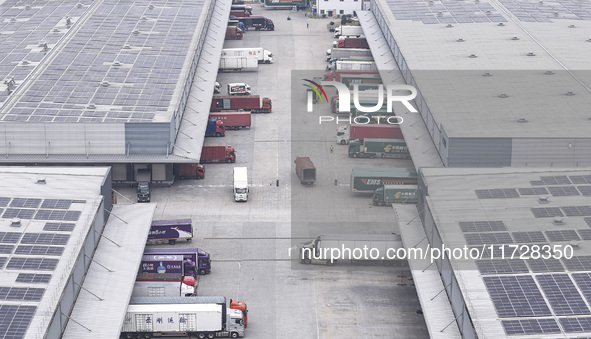 Express trucks from several companies load and unload parcels at a logistics park in the Huaian Economic and Technological Development Zone...