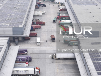 Express trucks from several companies load and unload parcels at a logistics park in the Huaian Economic and Technological Development Zone...