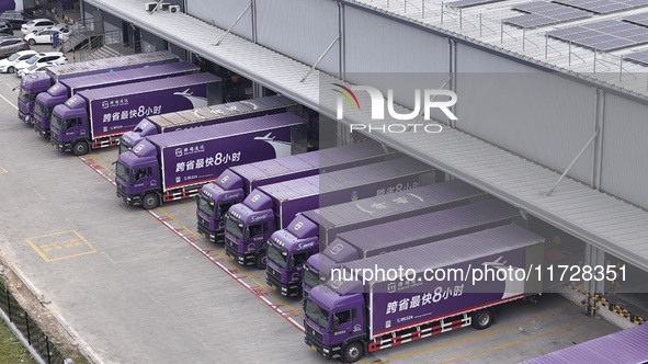 Express trucks from several companies load and unload parcels at a logistics park in the Huaian Economic and Technological Development Zone...