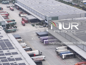 Express trucks from several companies load and unload parcels at a logistics park in the Huaian Economic and Technological Development Zone...