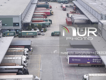 Express trucks from several companies load and unload parcels at a logistics park in the Huaian Economic and Technological Development Zone...