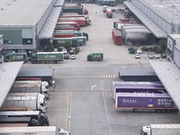 Express trucks from several companies load and unload parcels at a logistics park in the Huaian Economic and Technological Development Zone...