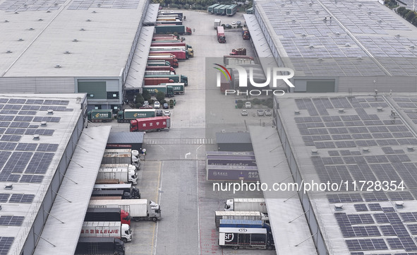 Express trucks from several companies load and unload parcels at a logistics park in the Huaian Economic and Technological Development Zone...