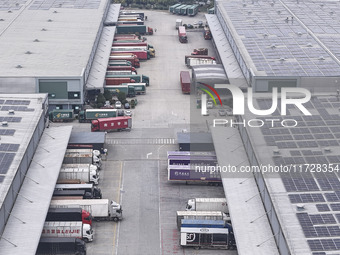 Express trucks from several companies load and unload parcels at a logistics park in the Huaian Economic and Technological Development Zone...