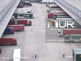 Express trucks from several companies load and unload parcels at a logistics park in the Huaian Economic and Technological Development Zone...