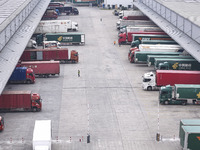 Express trucks from several companies load and unload parcels at a logistics park in the Huaian Economic and Technological Development Zone...