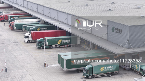 Express trucks from several companies load and unload parcels at a logistics park in the Huaian Economic and Technological Development Zone...