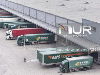 Express trucks from several companies load and unload parcels at a logistics park in the Huaian Economic and Technological Development Zone...