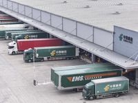 Express trucks from several companies load and unload parcels at a logistics park in the Huaian Economic and Technological Development Zone...