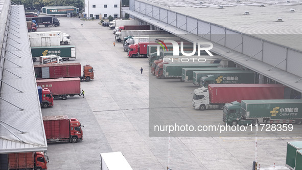 Express trucks from several companies load and unload parcels at a logistics park in the Huaian Economic and Technological Development Zone...