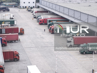 Express trucks from several companies load and unload parcels at a logistics park in the Huaian Economic and Technological Development Zone...