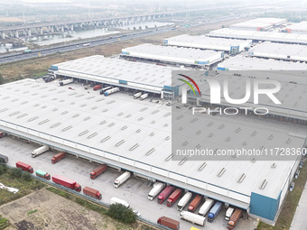 Express trucks from several companies load and unload parcels at a logistics park in the Huaian Economic and Technological Development Zone...