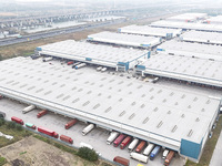 Express trucks from several companies load and unload parcels at a logistics park in the Huaian Economic and Technological Development Zone...