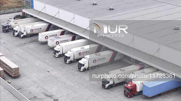 Express trucks from several companies load and unload parcels at a logistics park in the Huaian Economic and Technological Development Zone...