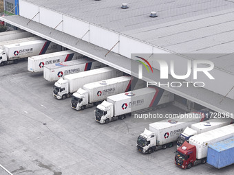 Express trucks from several companies load and unload parcels at a logistics park in the Huaian Economic and Technological Development Zone...