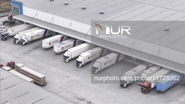 Express trucks from several companies load and unload parcels at a logistics park in the Huaian Economic and Technological Development Zone...