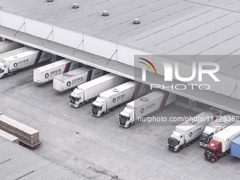 Express trucks from several companies load and unload parcels at a logistics park in the Huaian Economic and Technological Development Zone...