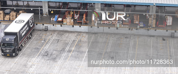 Express trucks from several companies load and unload parcels at a logistics park in the Huaian Economic and Technological Development Zone...