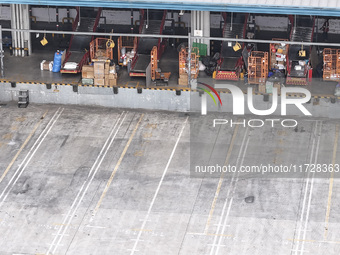 Express trucks from several companies load and unload parcels at a logistics park in the Huaian Economic and Technological Development Zone...