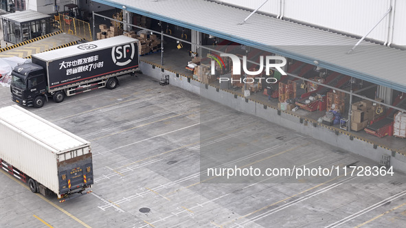 Express trucks from several companies load and unload parcels at a logistics park in the Huaian Economic and Technological Development Zone...