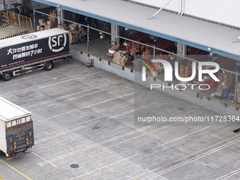 Express trucks from several companies load and unload parcels at a logistics park in the Huaian Economic and Technological Development Zone...