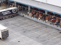 Express trucks from several companies load and unload parcels at a logistics park in the Huaian Economic and Technological Development Zone...