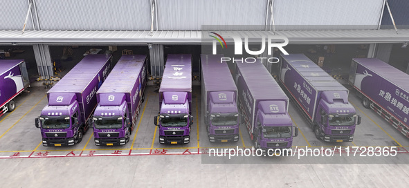 Express trucks from several companies load and unload parcels at a logistics park in the Huaian Economic and Technological Development Zone...