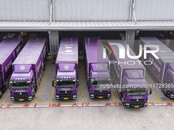 Express trucks from several companies load and unload parcels at a logistics park in the Huaian Economic and Technological Development Zone...