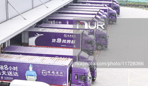 Express trucks from several companies load and unload parcels at a logistics park in the Huaian Economic and Technological Development Zone...