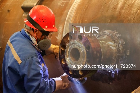 An employee works on a large pressure vessel customized by an oil refinery at the production workshop of Qingdao Lanshi Heavy Machinery Equi...