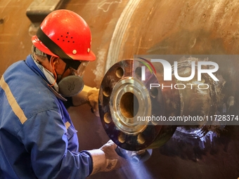 An employee works on a large pressure vessel customized by an oil refinery at the production workshop of Qingdao Lanshi Heavy Machinery Equi...