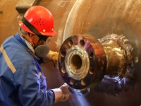 An employee works on a large pressure vessel customized by an oil refinery at the production workshop of Qingdao Lanshi Heavy Machinery Equi...