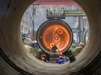 An employee works on a large pressure vessel customized by an oil refinery at the production workshop of Qingdao Lanshi Heavy Machinery Equi...