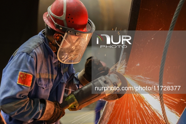 An employee works on a large pressure vessel customized by an oil refinery at the production workshop of Qingdao Lanshi Heavy Machinery Equi...