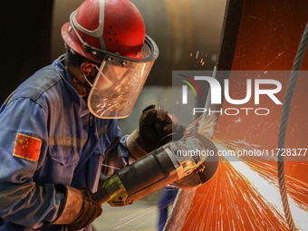 An employee works on a large pressure vessel customized by an oil refinery at the production workshop of Qingdao Lanshi Heavy Machinery Equi...