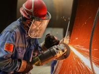 An employee works on a large pressure vessel customized by an oil refinery at the production workshop of Qingdao Lanshi Heavy Machinery Equi...