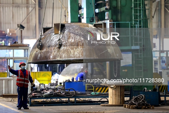 An employee works on a large pressure vessel customized by an oil refinery at the production workshop of Qingdao Lanshi Heavy Machinery Equi...