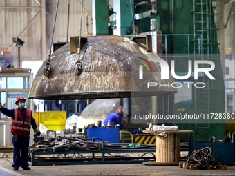 An employee works on a large pressure vessel customized by an oil refinery at the production workshop of Qingdao Lanshi Heavy Machinery Equi...