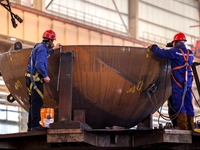 An employee works on a large pressure vessel customized by an oil refinery at the production workshop of Qingdao Lanshi Heavy Machinery Equi...