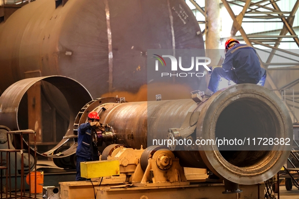 An employee works on a large pressure vessel customized by an oil refinery at the production workshop of Qingdao Lanshi Heavy Machinery Equi...