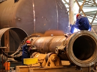 An employee works on a large pressure vessel customized by an oil refinery at the production workshop of Qingdao Lanshi Heavy Machinery Equi...