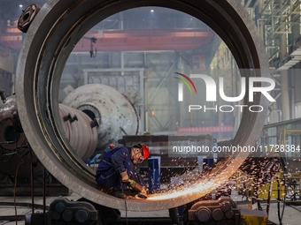 An employee works on a large pressure vessel customized by an oil refinery at the production workshop of Qingdao Lanshi Heavy Machinery Equi...